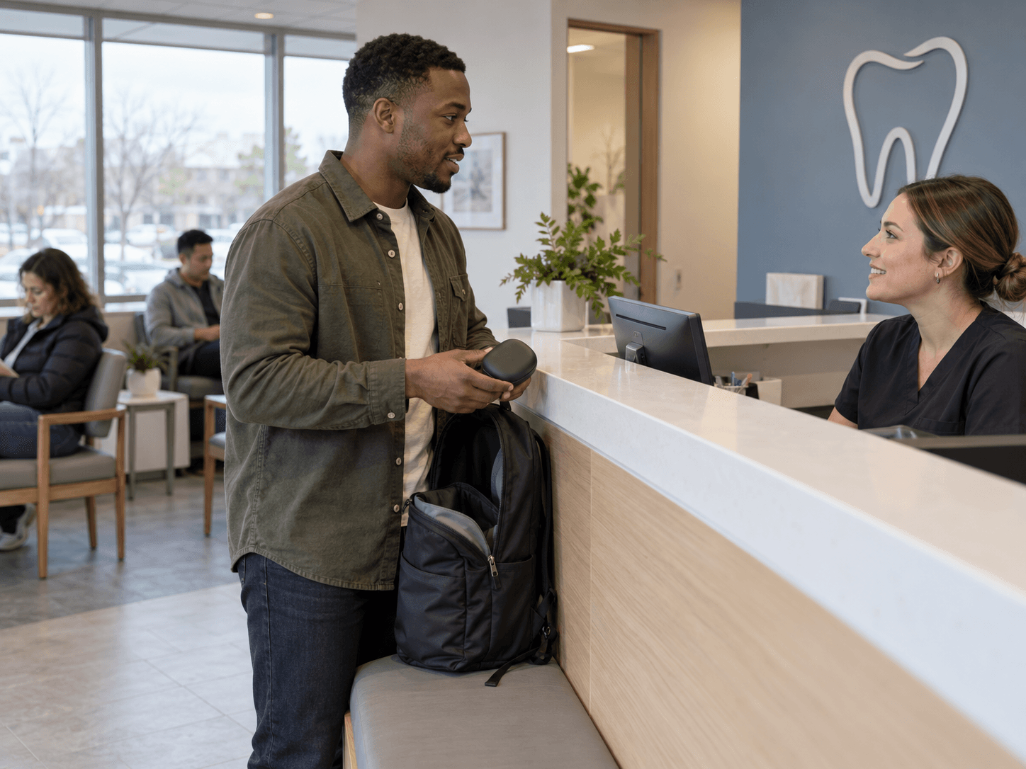 A man takes his aligner case from his bag at a follow-up appointment.