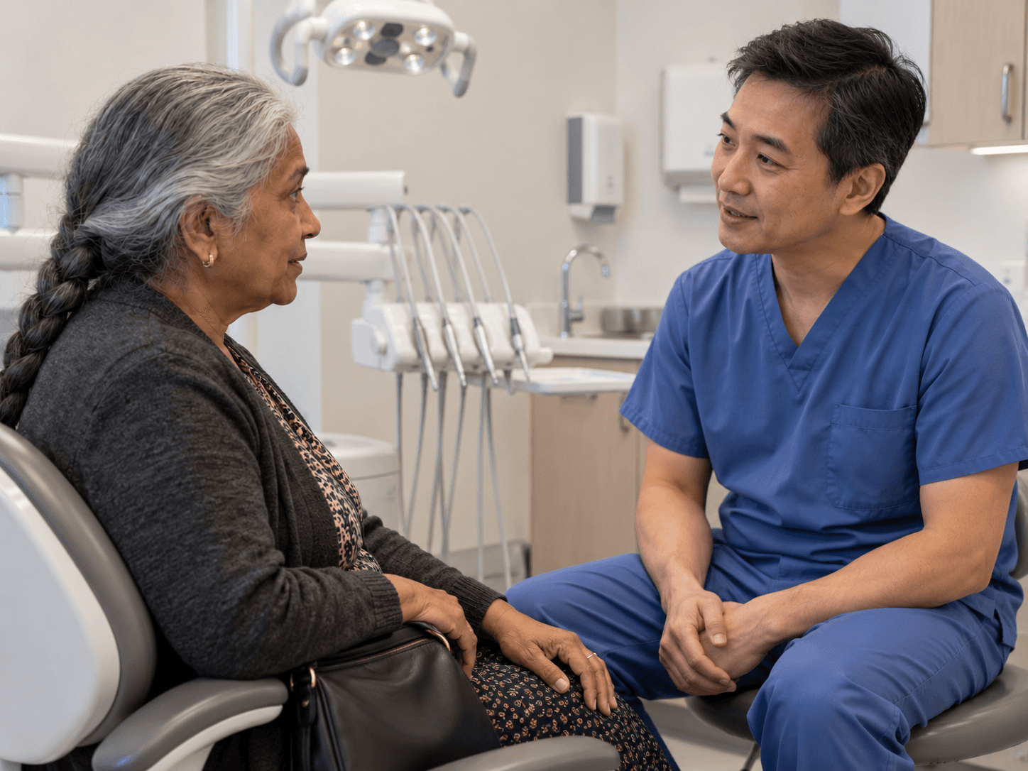 A woman discusses her medical treatment with a dentist before making a dental plan.