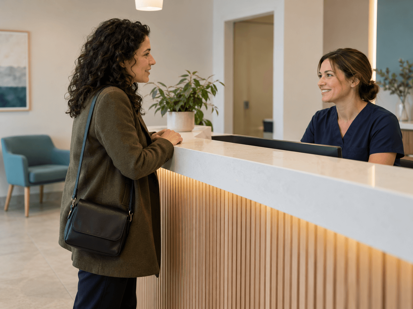 A woman speaks with a receptionist on arrival for a dental imaging appointment.
