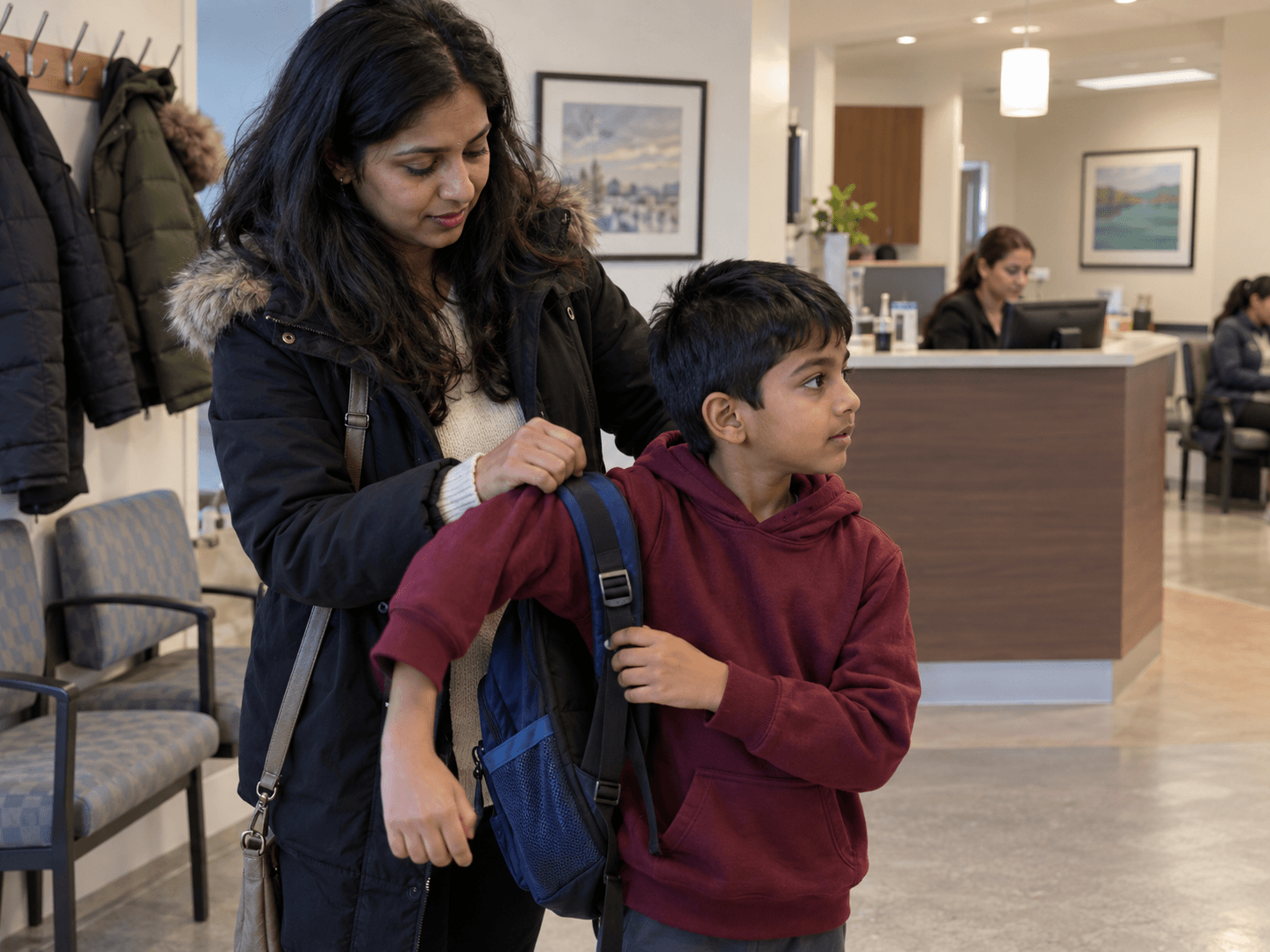A parent helps a child take off his backpack on arrival for a dental review.
